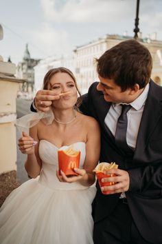 a bride and groom are eating french fries