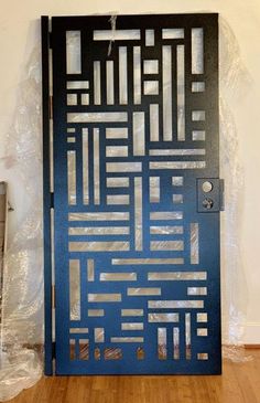 a blue door with metal designs on it in the middle of a wooden flooring area