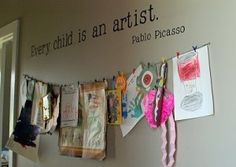 there are many pictures hanging on the wall with words above them and below it is a sign that says every child is an artist