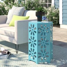 a blue side table sitting on top of a patio next to a couch and chair