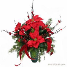 a vase filled with red poinsettia and greenery on top of a table