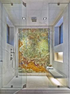 the inside of a bathroom with glass walls and an artistic painting on the shower wall