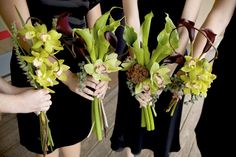 four women in black dresses holding bouquets of flowers