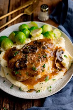 a plate with mashed potatoes, brussel sprouts and gravy