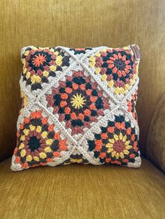 a crocheted pillow sitting on top of a couch