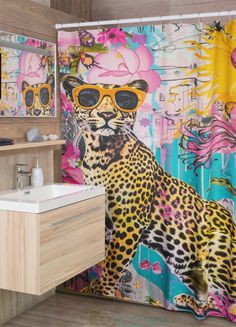 a shower curtain with a leopard wearing sunglasses on it's face, next to a sink and mirror