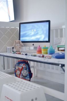 a computer monitor sitting on top of a desk next to a toy car and other toys