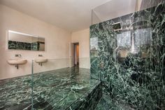 a bathroom with green marble floors and walls