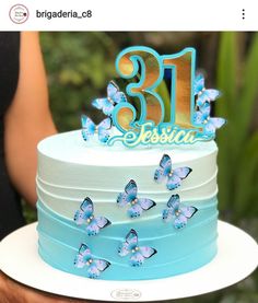 a blue and white birthday cake with butterflies on the top that says 31 lessu