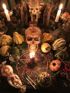 a skull sitting on top of a table surrounded by candles