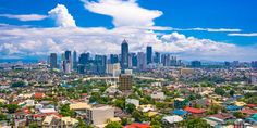 an aerial view of a city with tall buildings in the foreground and clouds in the background