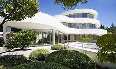 a white building with curved windows and trees