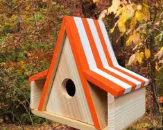 a birdhouse with an orange and white striped roof