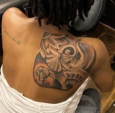 the back of a woman's shoulder with an elephant tattoo on her left side