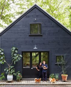 two people standing in front of a black house