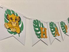 a lion themed banner with leaves and the letter h on it's front, hanging from a wall