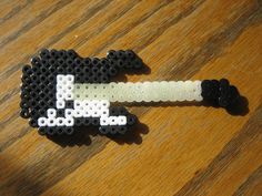 a black and white beaded dog with a bone in it's mouth on a wooden table