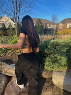 a woman is sitting on some rocks outside