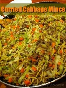 a pan filled with noodles and vegetables on top of a wooden table