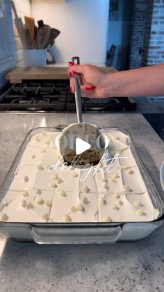 a person scooping food into a pan on top of a counter