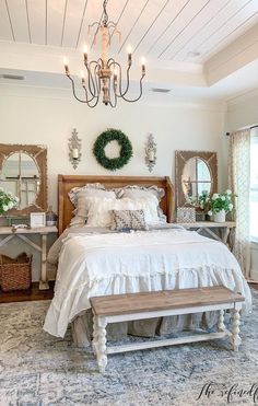 a bedroom with a large bed and chandelier hanging from it's ceiling