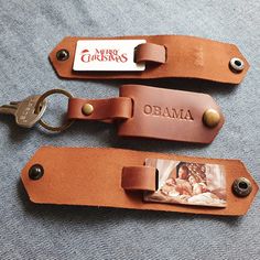 two leather keychains with the name obama and an image of a woman on them