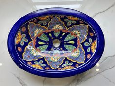 a blue bowl with an intricate design on the bottom sits on a marble countertop