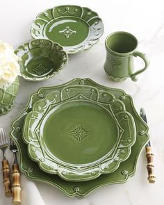 a table set with green dishes and silverware