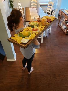 a woman carrying a long table full of food