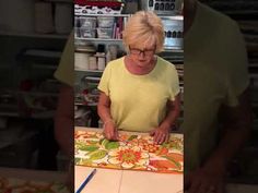 an older woman is making a quilt with scissors