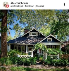 a small blue and white house with trees in the front yard is featured on instagram