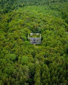 an aerial view of a house in the middle of a forest with lots of trees