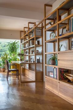 a room filled with lots of wooden bookshelves next to a table and chairs