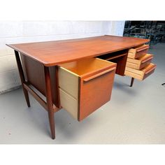 a wooden desk with two drawers on the top and one drawer open in front of it