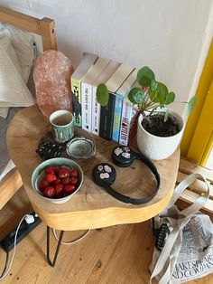 a wooden table topped with books and fruit on top of it next to a plant