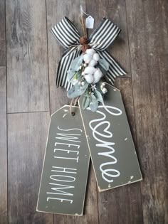 two tags with the words welcome and cotton flowers on them hanging from a wooden floor