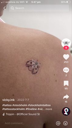 the back of a person's shoulder with a tattoo on it and an image of a bee