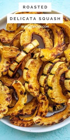 roasted delicata squash in a white bowl on a blue surface with text overlay