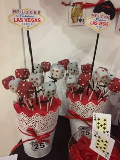 there are many cupcakes on sticks in the bucket with red bows and lace