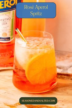 a close up of a drink in a glass with an orange slice on the rim