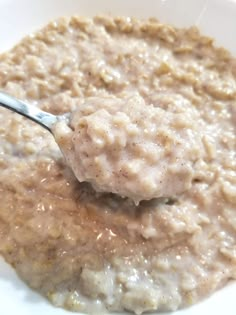 oatmeal in a white bowl with a spoon sticking out of the top