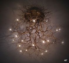 a light fixture with branches and lights hanging from it