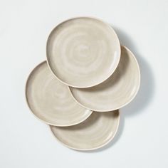 three white plates stacked on top of each other in the shape of spirals and circles