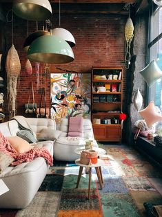 a living room filled with furniture next to a brick wall covered in lots of lights