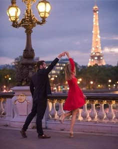 a couple dancing in front of the eiffel tower