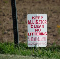 a sign that says keep alligator clean no littering $ 100, 000 dollar fine