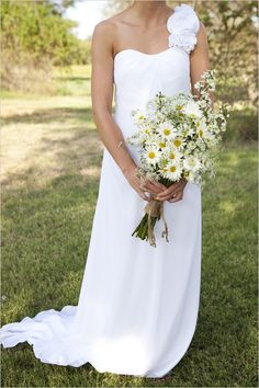 a woman in a white dress holding a bouquet of flowers