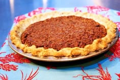 a pie sitting on top of a table next to a red and blue cloth covered tablecloth