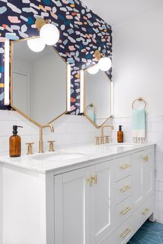 a bathroom with two sinks and three mirrors on the wall above them is decorated in blue, pink, yellow and white