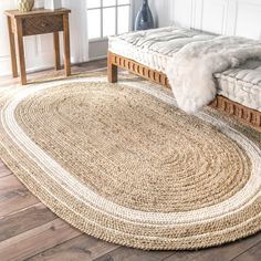 an oval rug is on the floor next to a bed